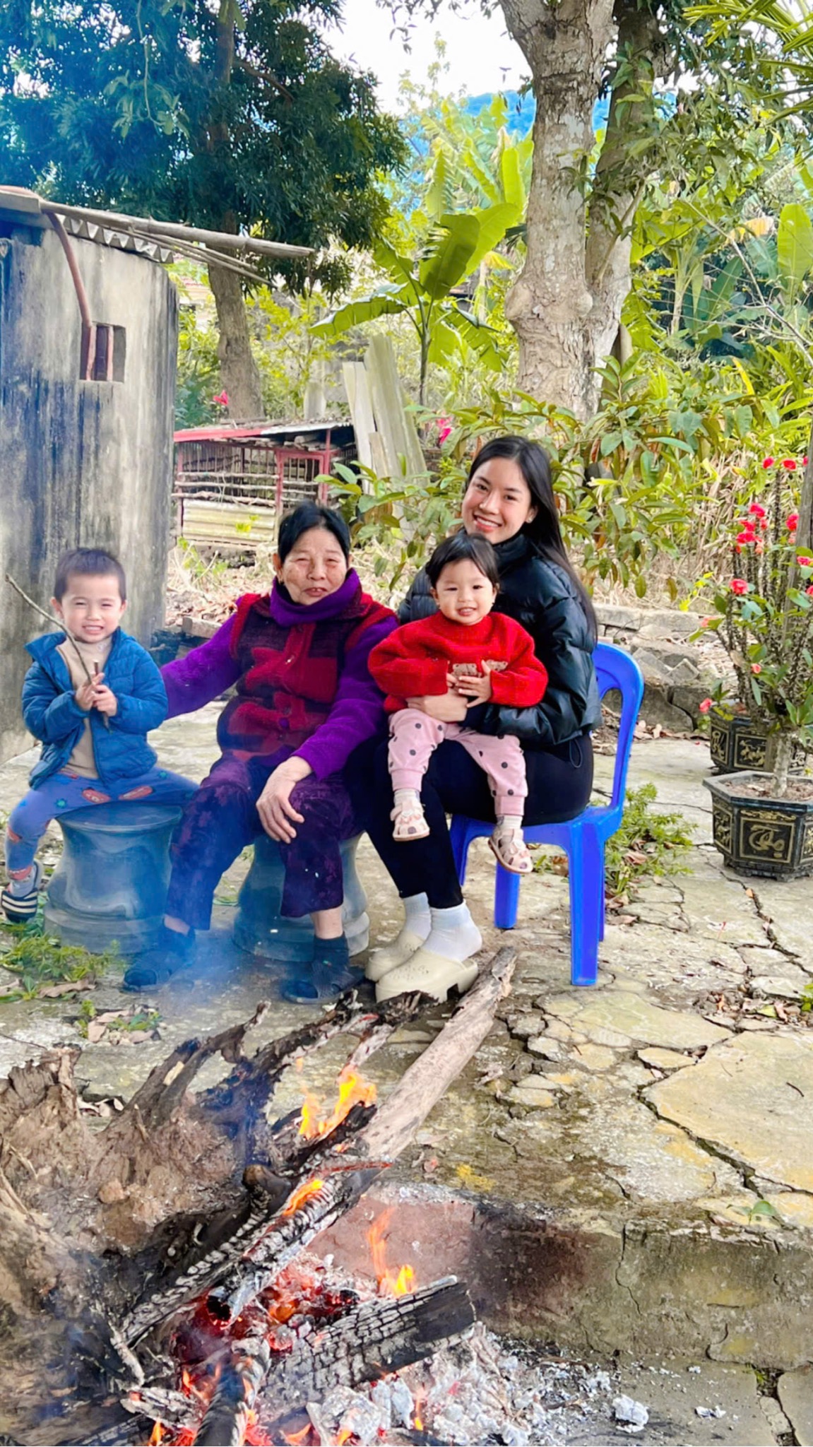 Chu Thị Hà bên mẹ và hai con nhỏ cạnh bếp lửa